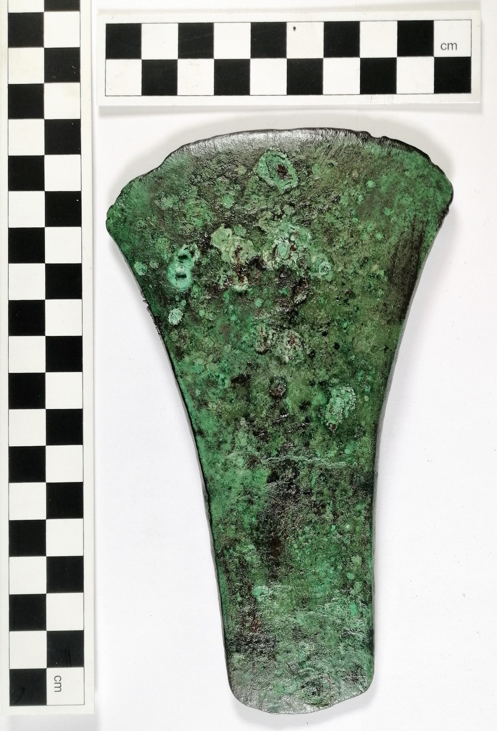 Bronze age axe head after treatment, showing lacquer coating.