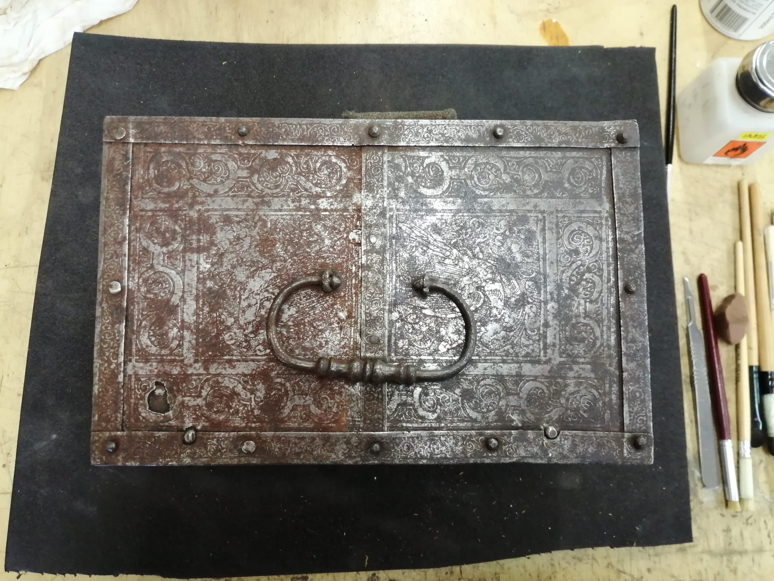 The progression of rust removal by scalpel cleaning, of a 17th C iron casket.